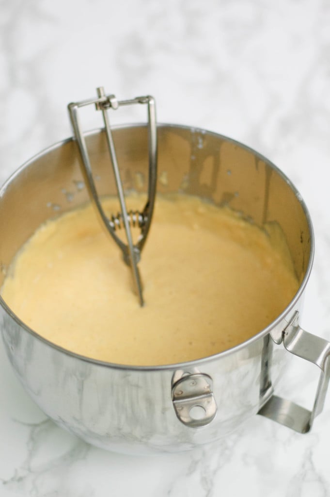 A mixing bowl of batter with a scoop in it.