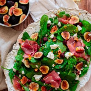 fig salad with goat cheese on a white platter.