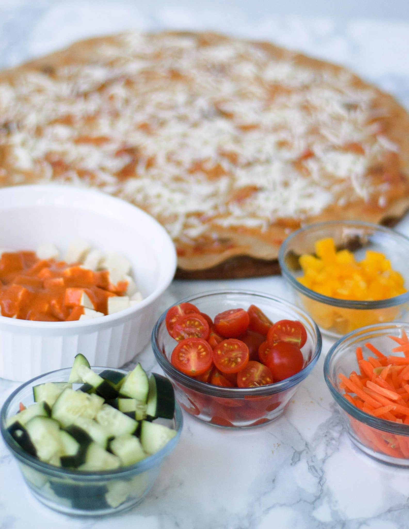 Ingredients for homemade pizza in front of the crust.