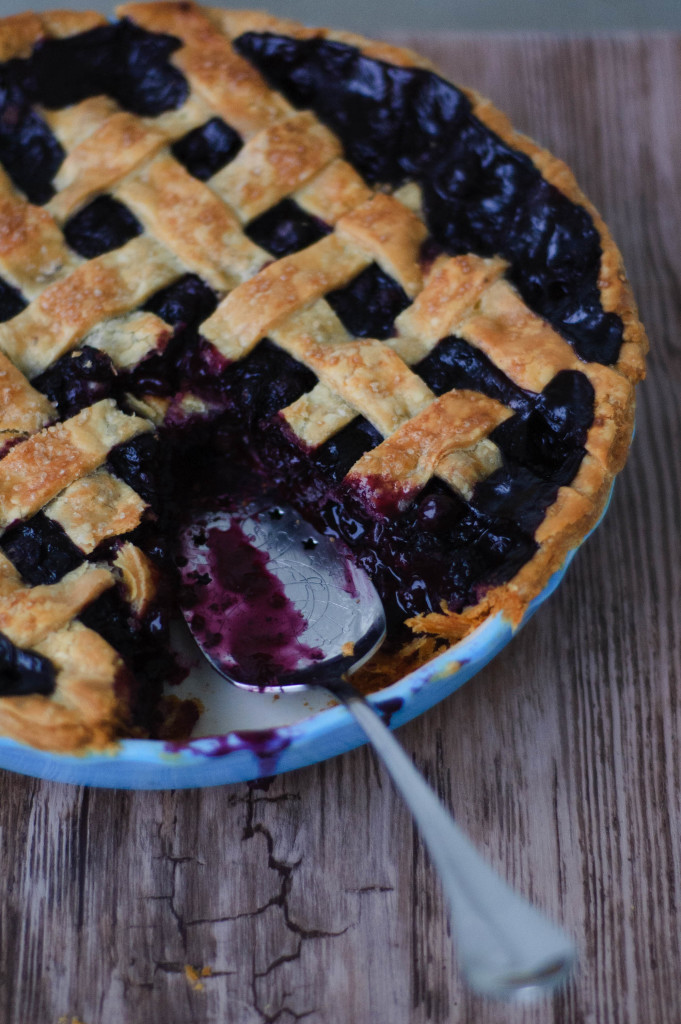 A pie spatula sticking out of missing slot of pie in a dish.