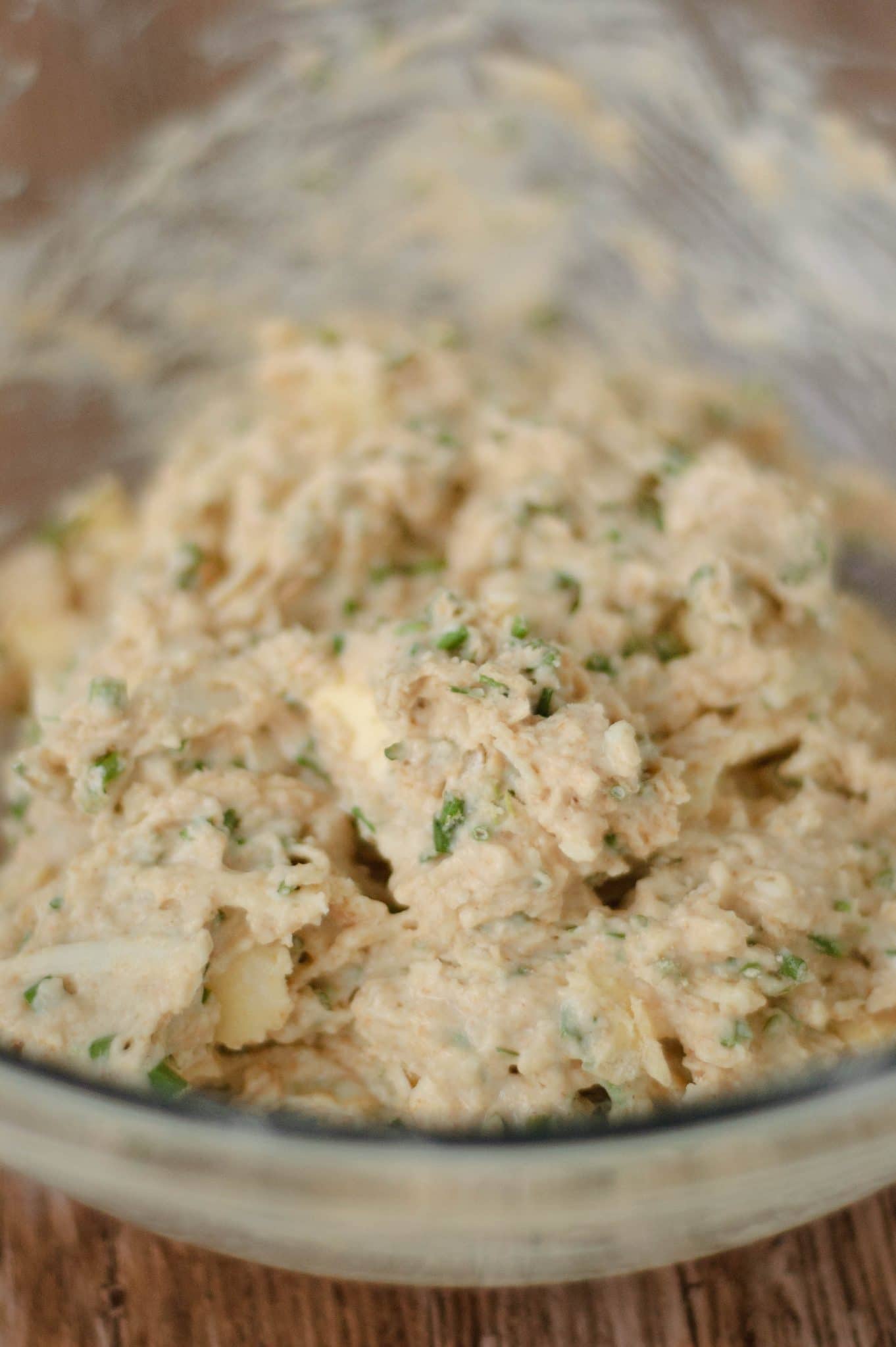 Parmesan chive biscuit dough in a clear bowl.