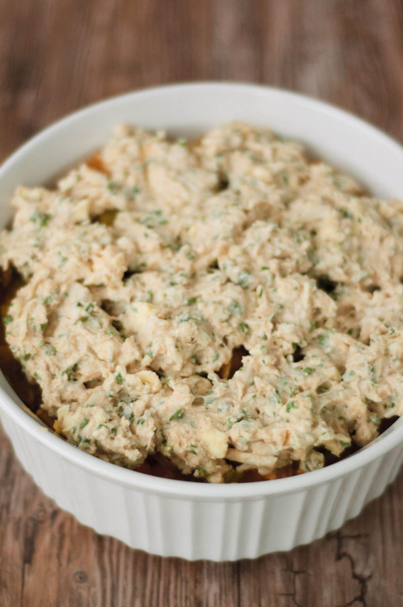 Biscuit dough covering the top of an autumn vegetable cobbler.