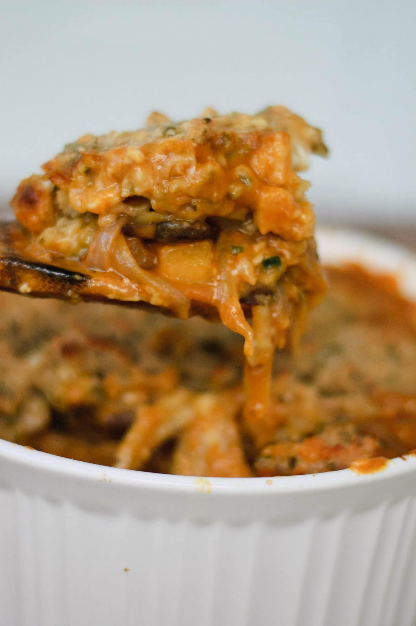 A spatula pulling pumpkin casserole out of a baking dish.