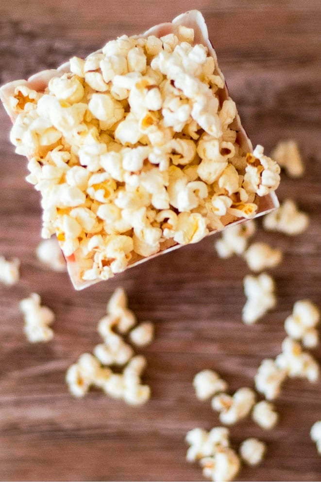 overhead view of stovetop popcorn spilling out of a container