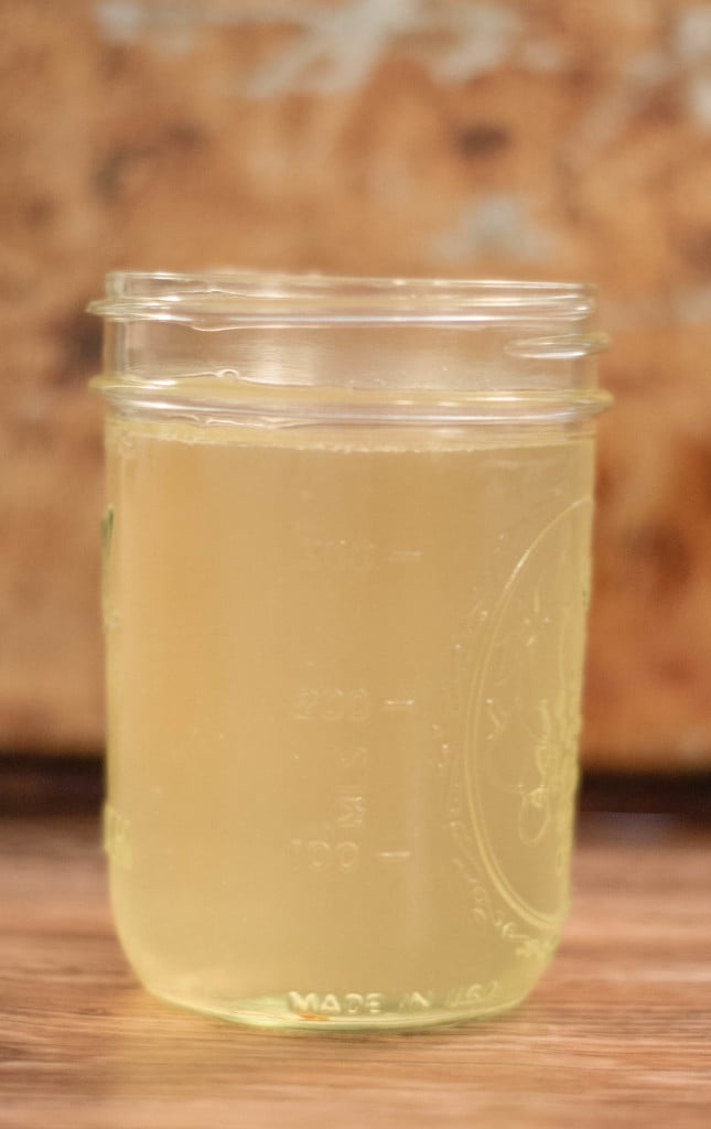 Side view of almost clear white stock in a mason jar.