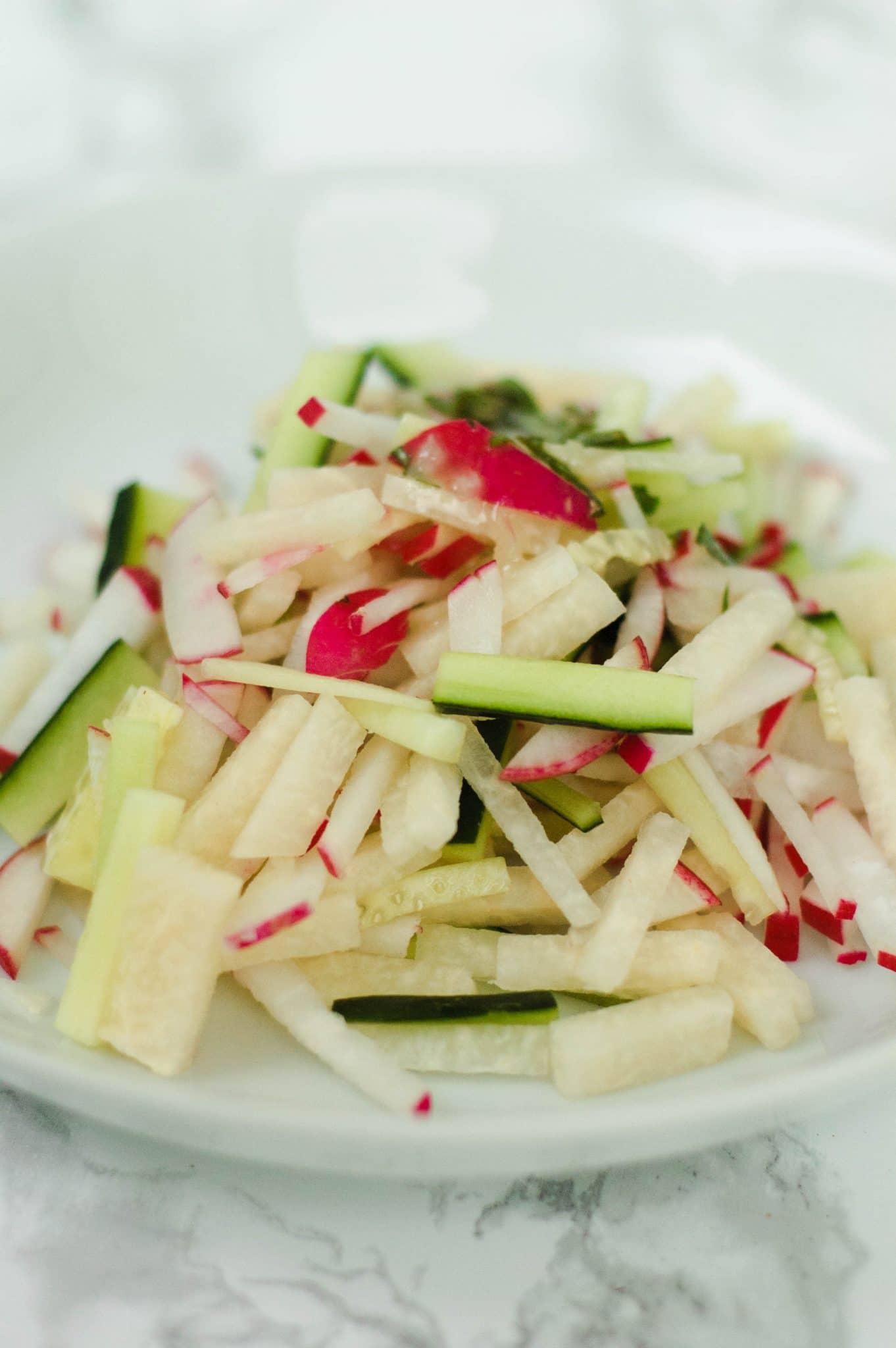 This light and refreshing radish, cucumber, & jicama salad with basil-mint vinaigrette is delightfully crunchy and slightly sweet. Perfect for a cookout!