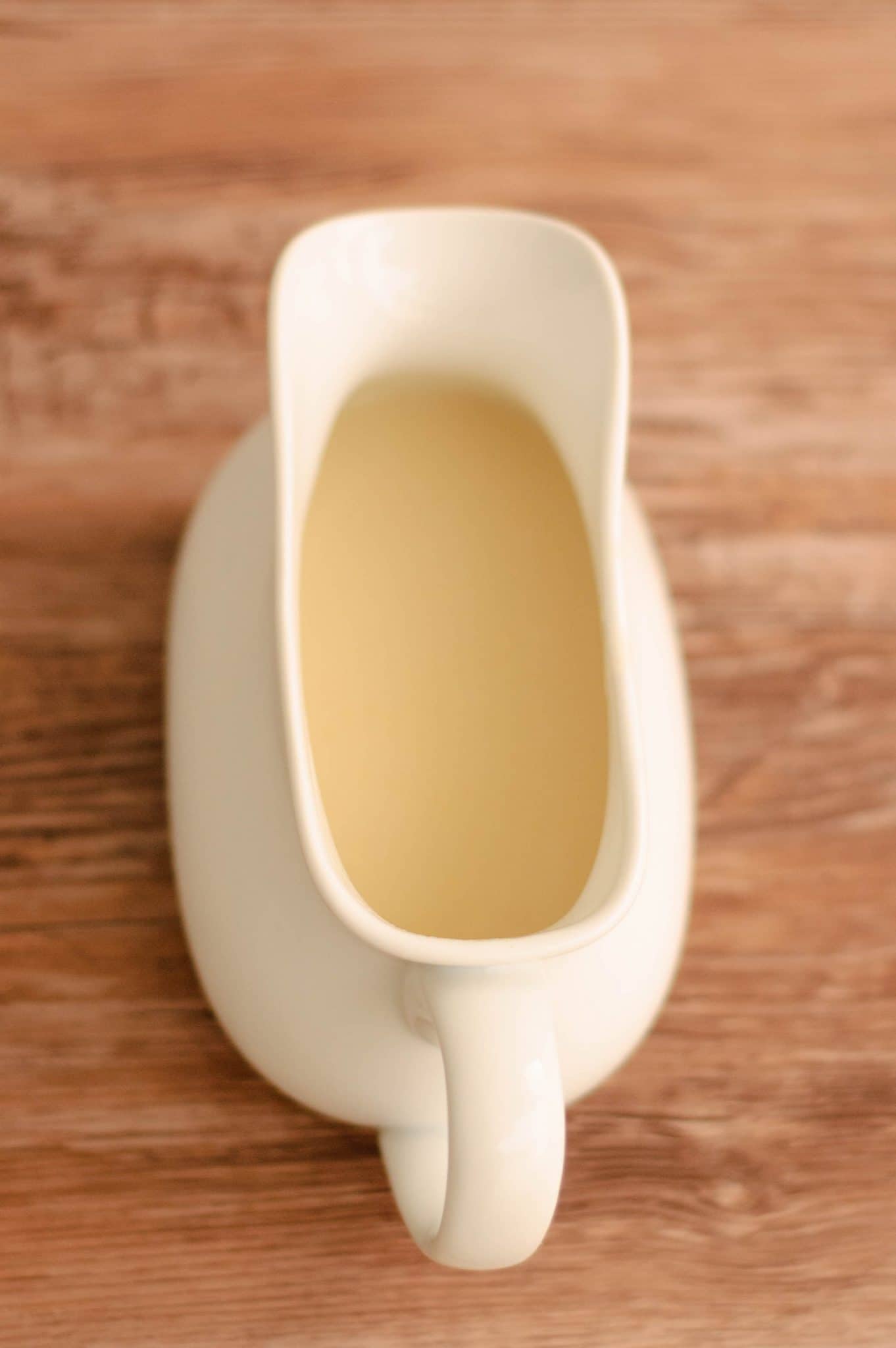 A gravy boat with a light creamy veloute sauce in it.