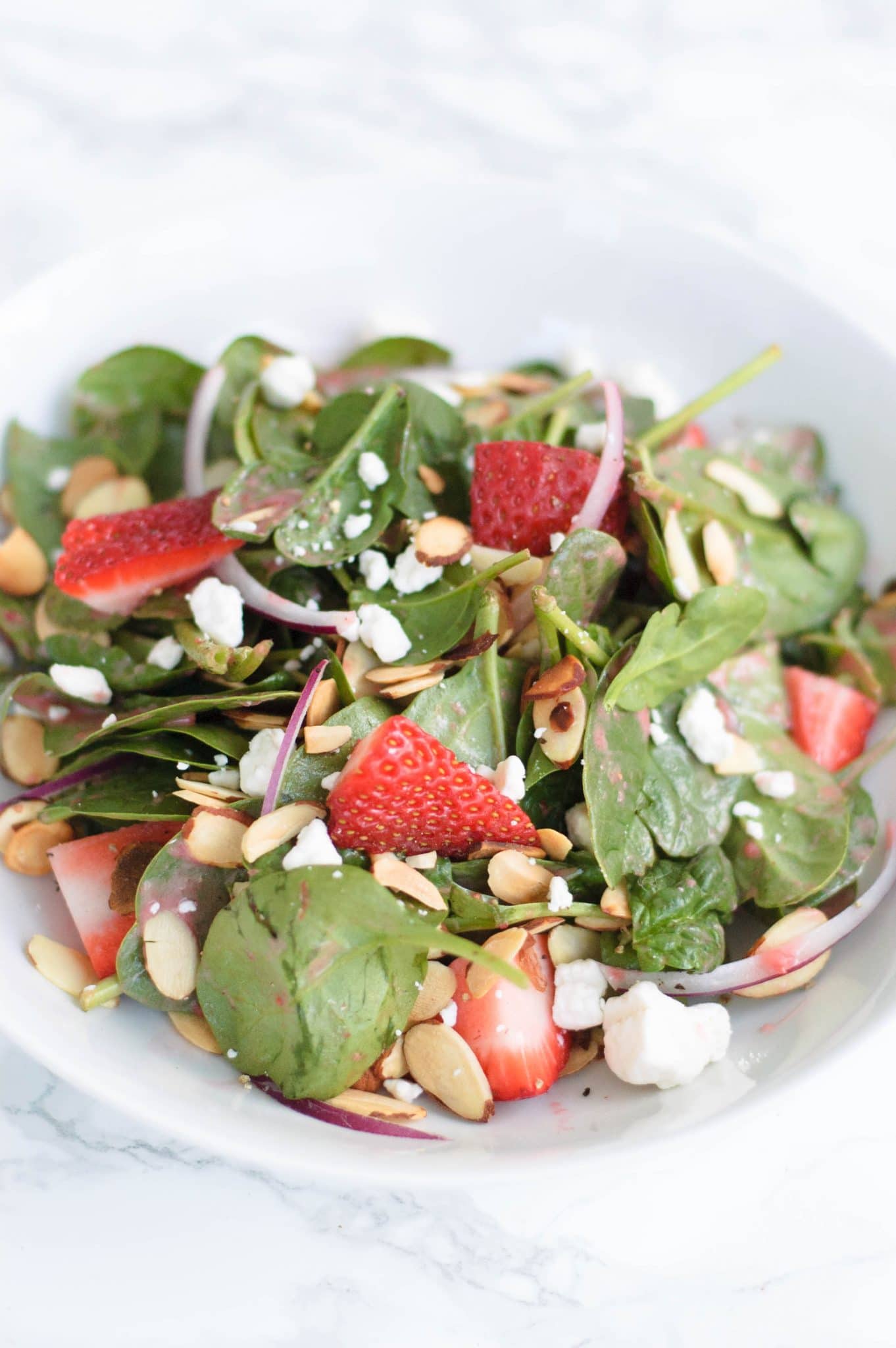 Enjoy this light and sweet strawberry, almond, and goat cheese salad that has a bright and zingy strawberry vinaigrette. The almonds give it a great crunch!