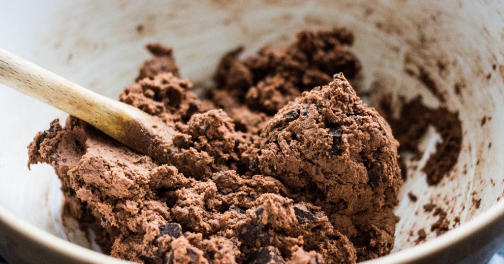 A white bowl with chocolate cookie dough in it