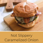 Square image of cutting board with burger on top and text saying "Not Slippery Caramelized Onion burger"