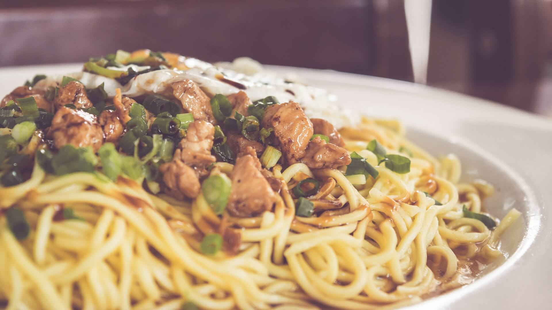 Stir fried meat on top of lo mein noddles.