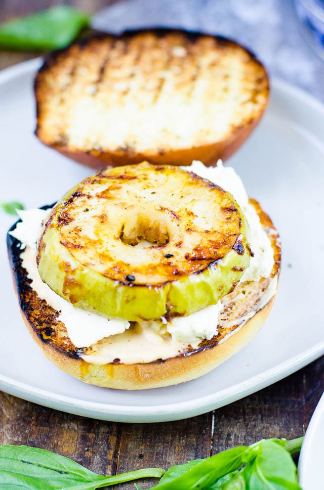 Grilled green apple on top of brie and a hamburger bun.