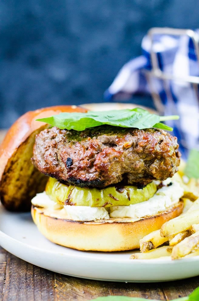 side view of a stacked brie burger with green apple and basil.
