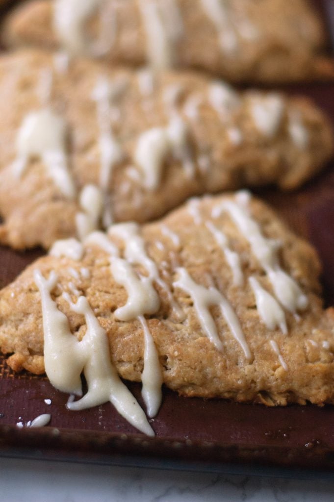 brown butter scones drizzled with brown butter icing on a baking mat