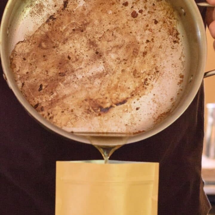A skillet pouring liquid grease into a container.