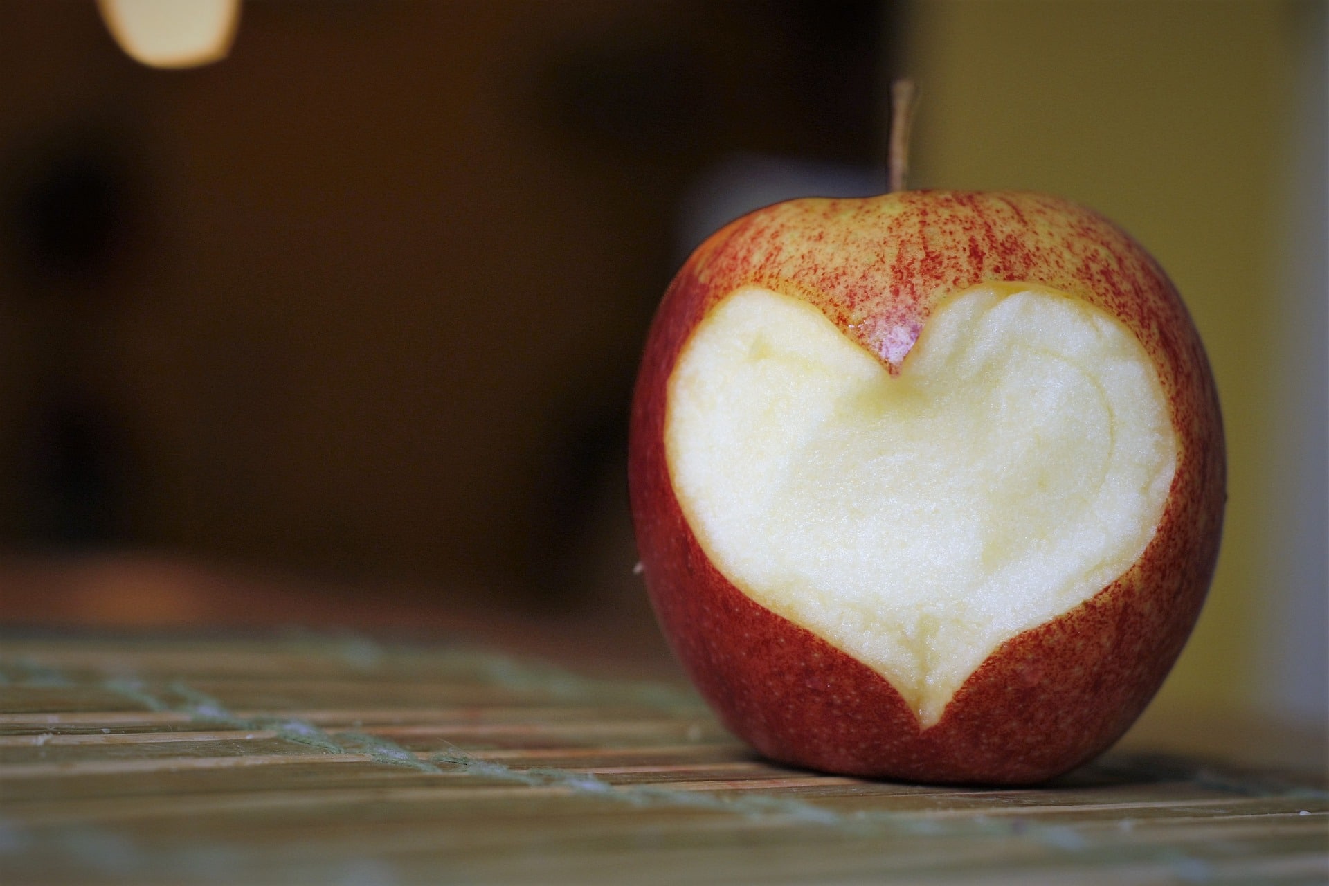 An apple with bites cut out to make a heart shape.