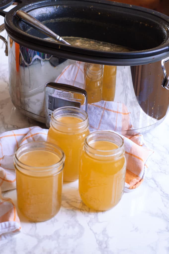 Homemade turkey stock in front of an all-clad slow cooker