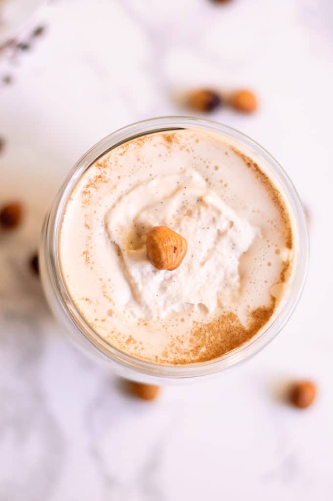 overhead image of coffee cocktail topped with fresh whipped cream and a single hazelnut in middle