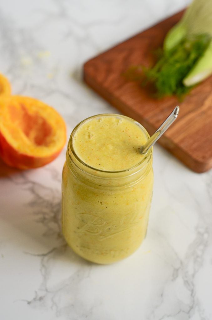 a mason jar of orange and fennel marinade with a spoon coming out.