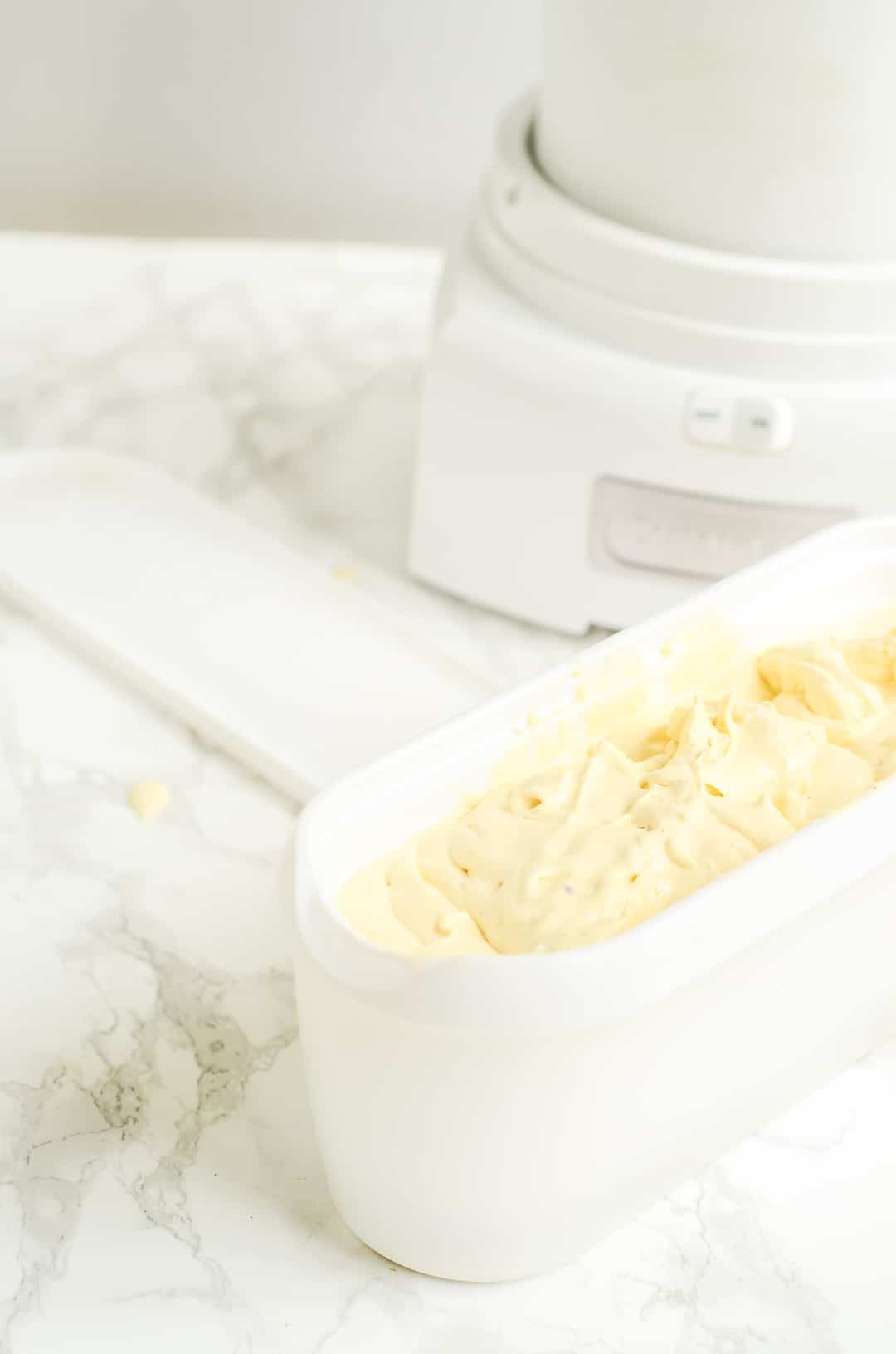 Tub of custard ice cream next to cuisinart ice cream maker