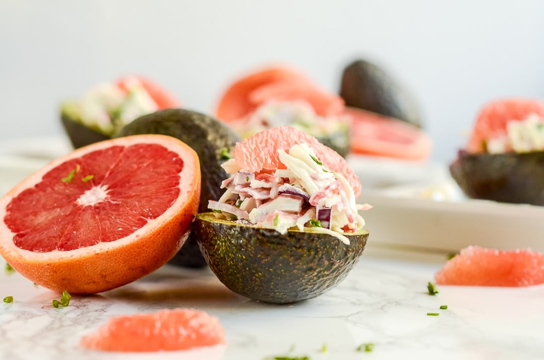 half an artichoke stuffed with crab and grapefruit next to half a grapefruit