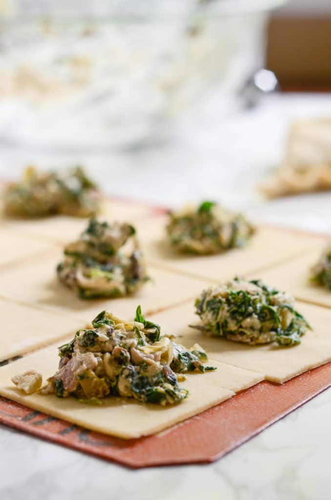 Spinach, bacon, chicken, artichoke filling on squares of pie dough