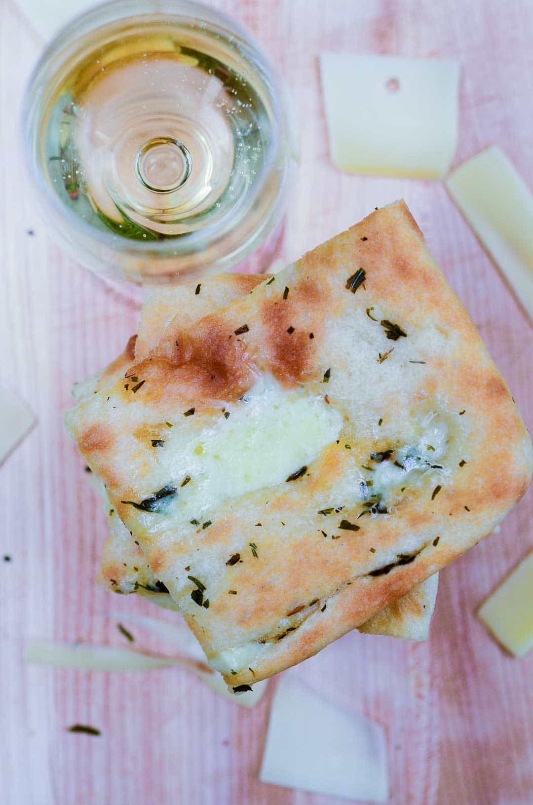 overhead view of a stack of slab grilled cheese and a glass of wine.