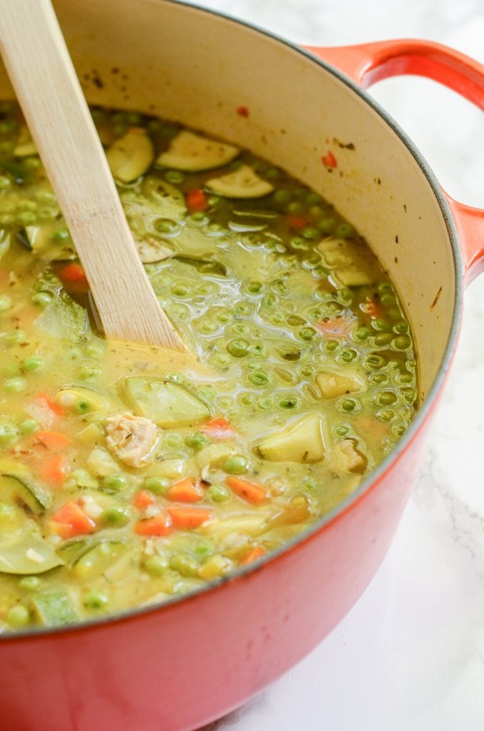 Lemony Couscous soup in a Le Creuset dutch oven with wooden spoon