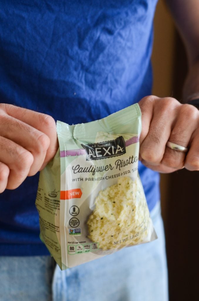 Hands opening a bag of Alexia frozen Riced Cauliflower Risotto