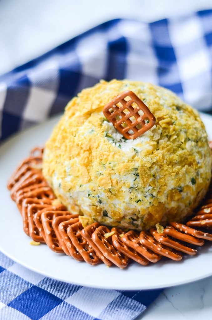 a square pretzel tucked into a Fire Roasted Jalapeno Cheese Ball surrounded by pretzels