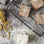 Brownies on a cooling rack next to a spice jar of cardamom