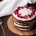 Layered chocolate cake next to fork and white napkin