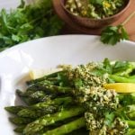 white plate of asparagus with gremolata topping