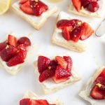 ten tartlets on a white surface next to fresh lemon