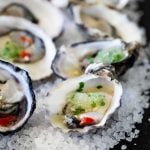 Seven halved Oysters with Granita on tops of rock salt