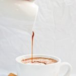 spicy chocolate being poured into white coffee mug