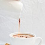 spicy chocolate being poured into white coffee mug