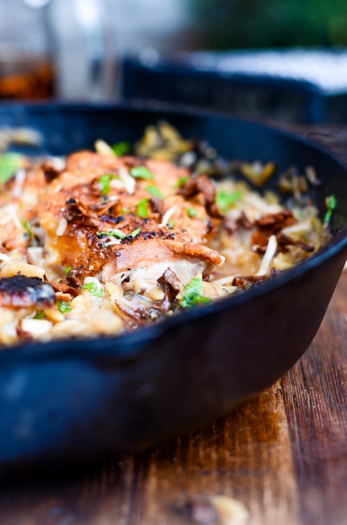 side view of cast iron pan with One Pan Chicken and Wild Mushroom Orzo