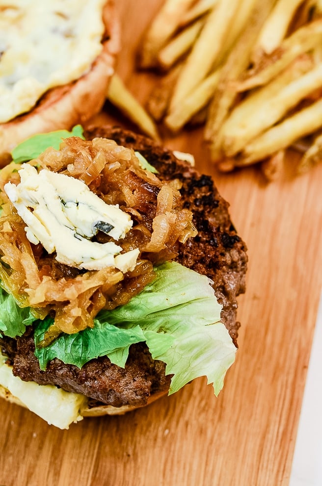 roasted garlic burger on a cutting board next to french fries