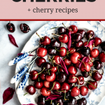 tray of cherries with title of "How to Pit Cherries + Cherry Recipes"