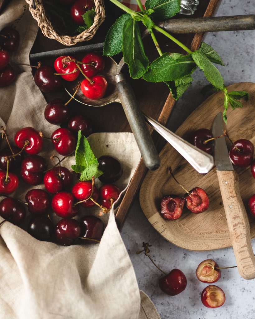 Red cherries on a tray with a knife.