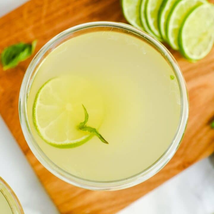 A bowl filled with liquid, along with a slice of lemon