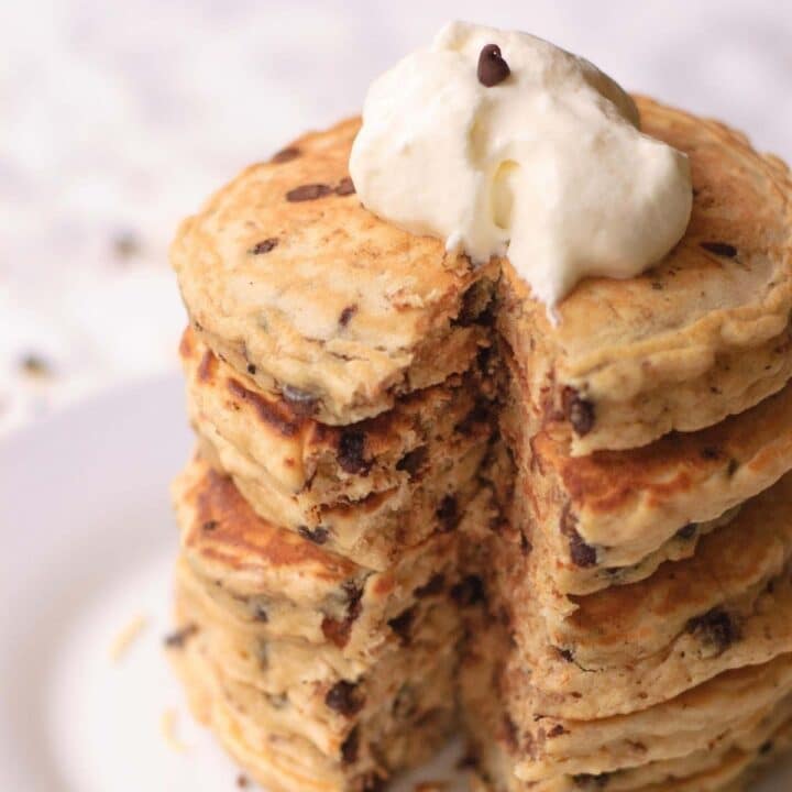 A stack on fluffy chocolate chip pancakes topped with a coconut cream