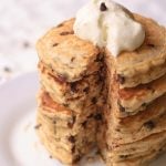 plate of Chocolate Chip Pancakes with Toasted Coconut topped with whipped cream