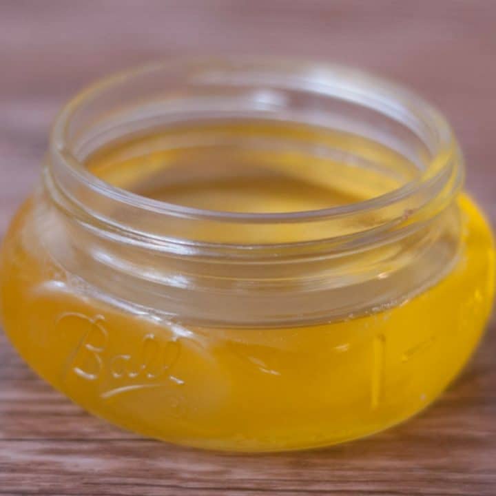 a small mason jar of clairified butter on a wooden board