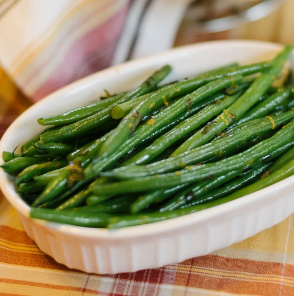 a small bowl of haricots verts on an autumnal colored tablecloth