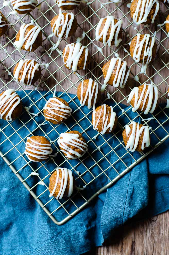 A cooling rack of biscoff cookie truffles on a wooden board with a blue napking