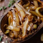 overhead image of a wooden bowl of caramelized onion at an angle