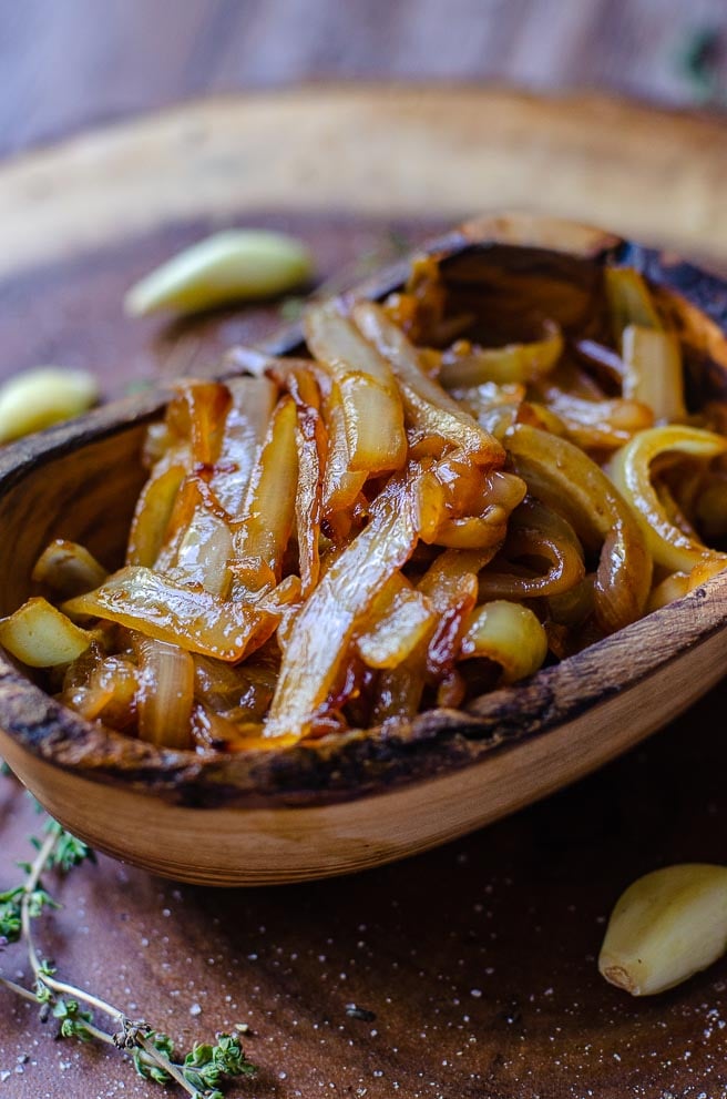 An ovular wooden bowl with caramelized onions