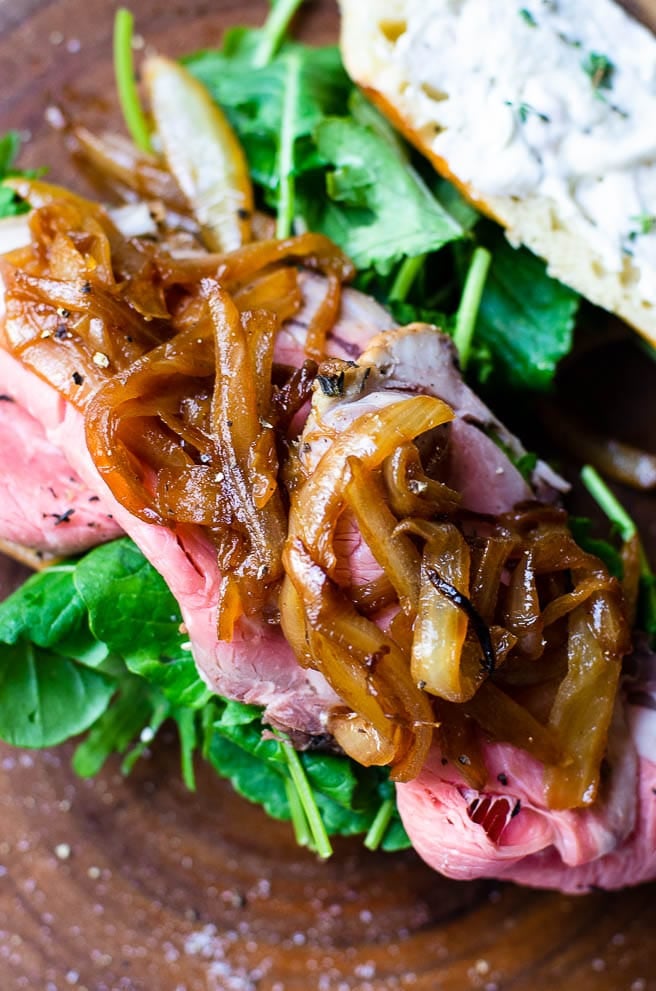 close up of caramelized onions on top of open face prime rib sandwich